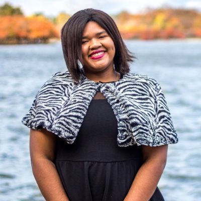 Photo of Angelica Vega smiling at the camera in front of lake